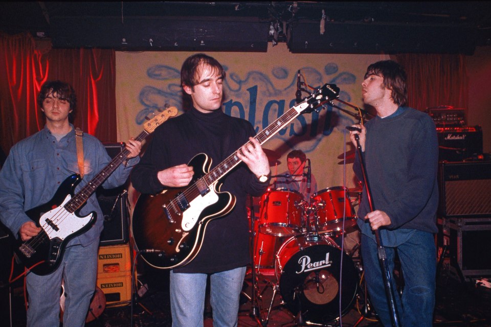 a man playing a guitar in front of a pearl drum set