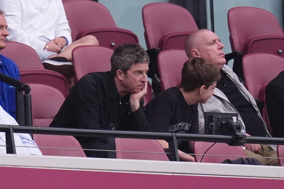 a man in a date shirt sits in the stands