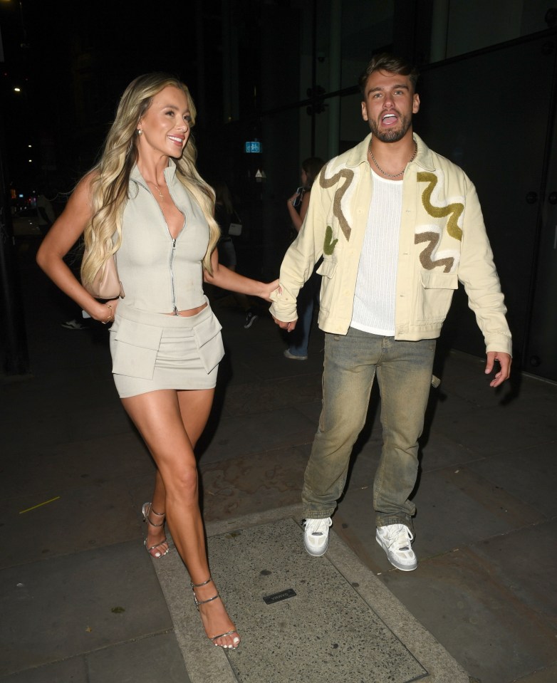 a man in a jacket with the letter r on it is holding a woman 's hand
