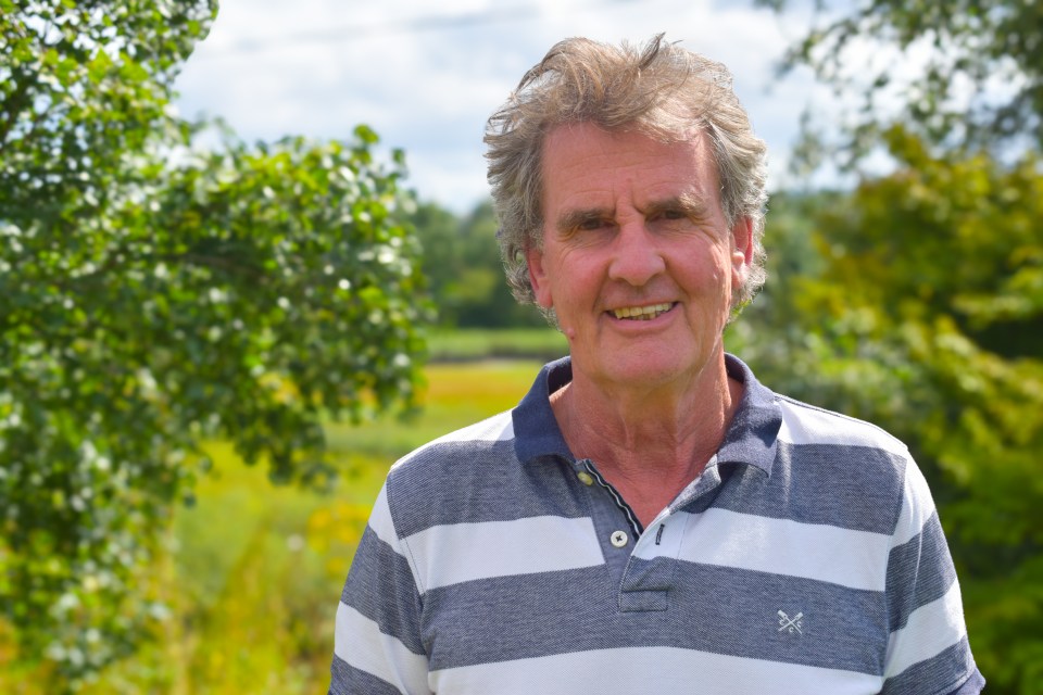a man wearing a striped shirt with an x on the front