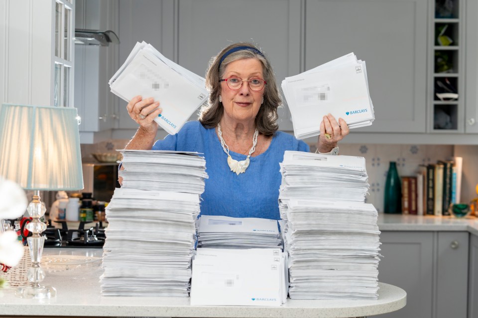 a woman holds up a stack of envelopes that say envelope