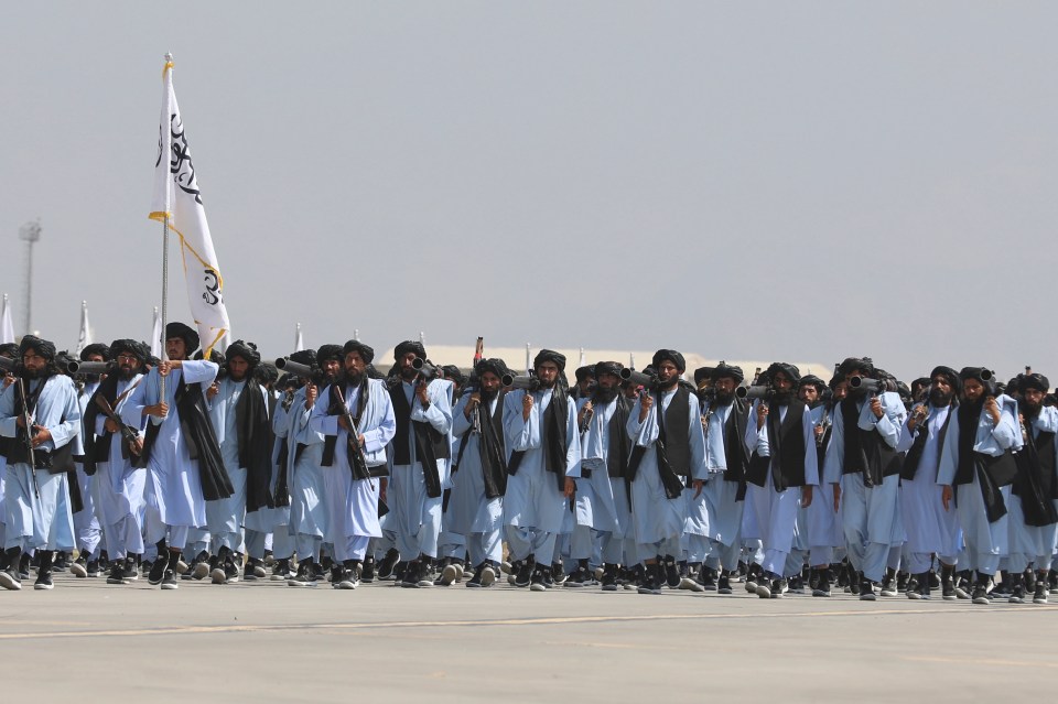 a group of men marching with a flag that says ' afghanistan ' on it