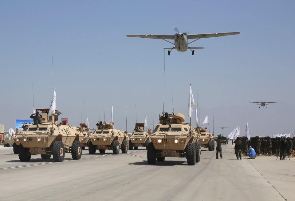 a group of military vehicles are lined up on a runway