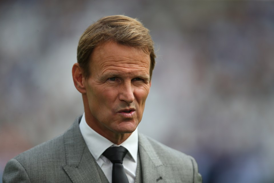 a man in a suit and tie stands in front of a crowd
