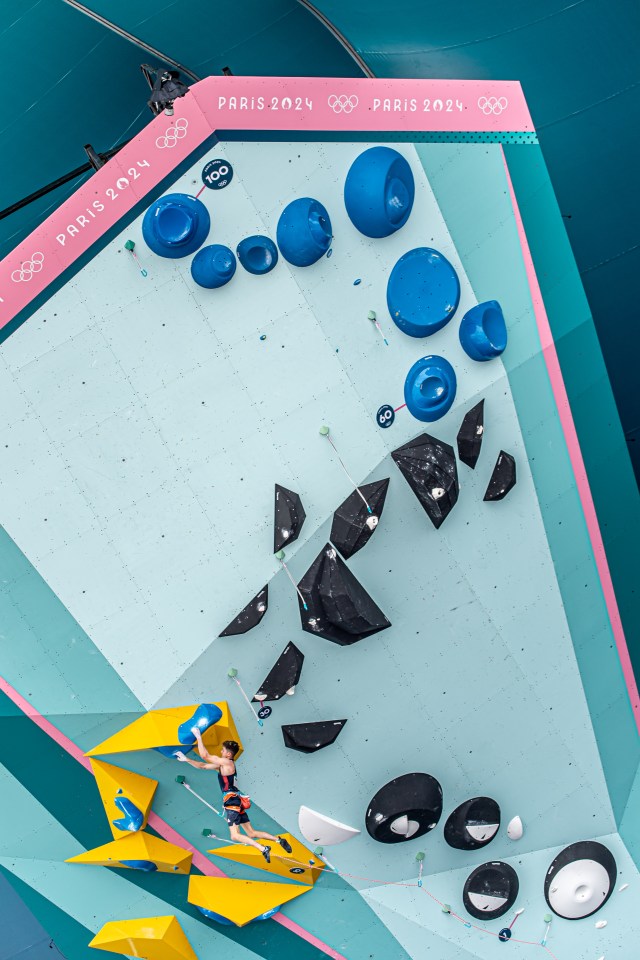 a man is climbing a wall with a british flag on his shirt