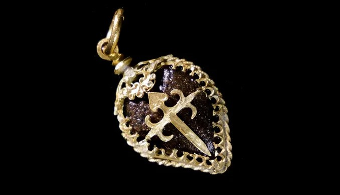 a collection of gold and silver jewelry including a coin that says ' emeralds ' on it