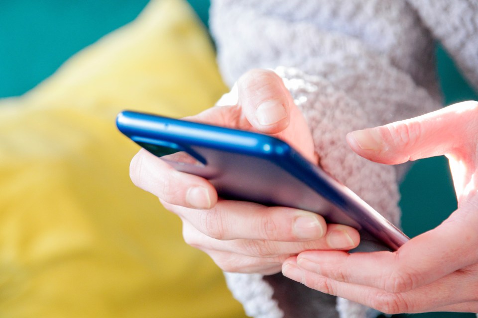 a person is holding a blue cell phone in their hands
