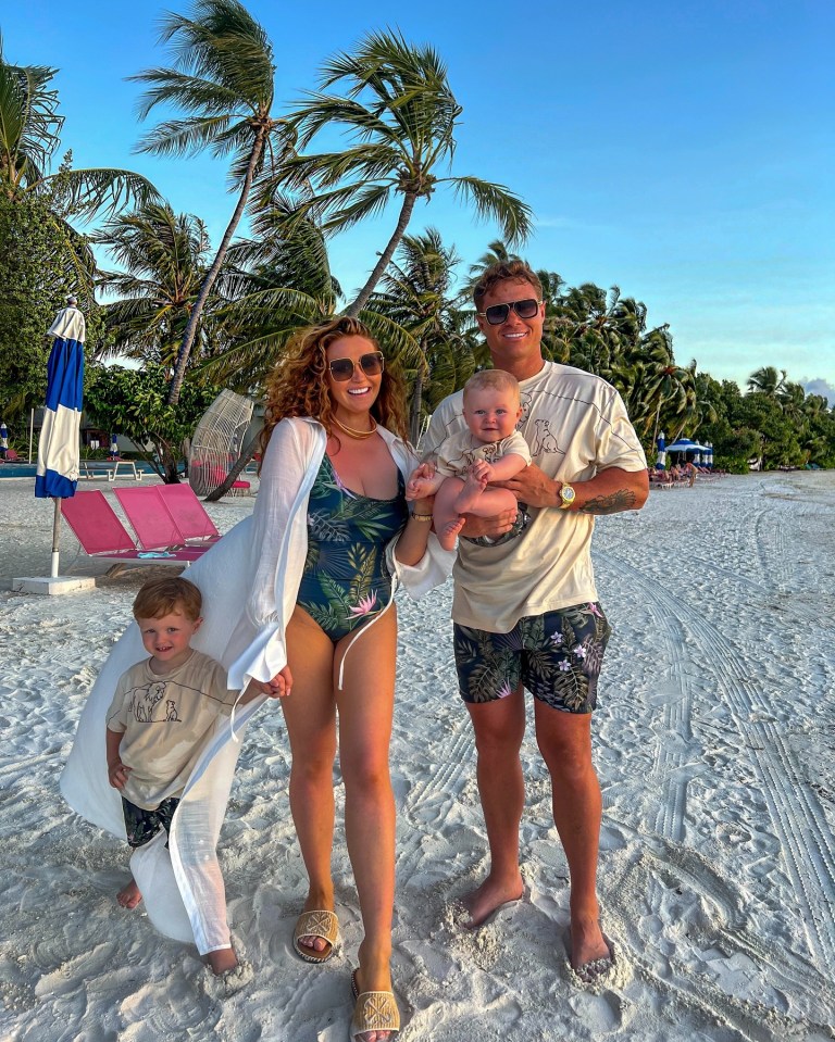 a family posing for a picture on a beach wearing matching shirts