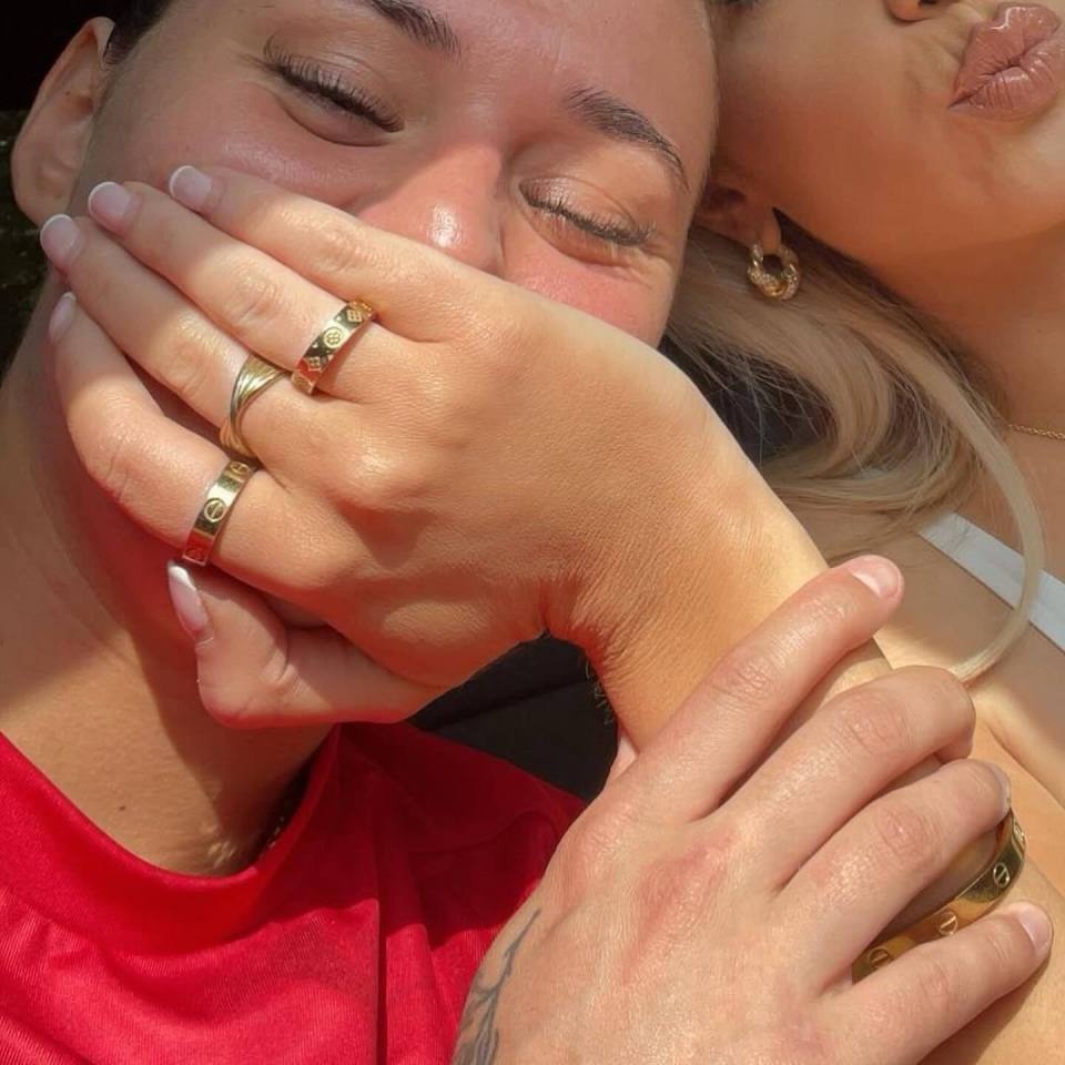 a woman kissing a man 's hand while wearing a cartier ring