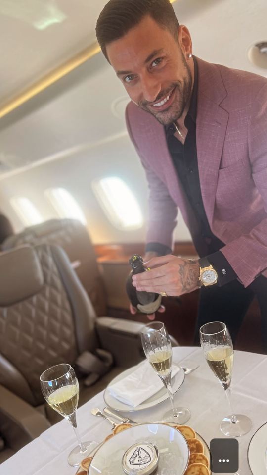 a man in a pink suit is pouring champagne into a glass