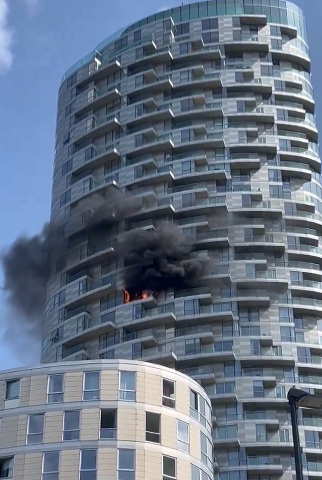 a tall building with smoke coming out of the windows