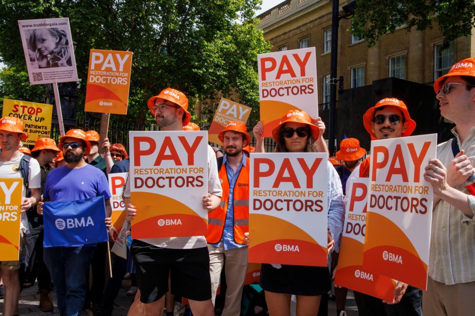 a group of people holding signs that say pay restoration for doctors