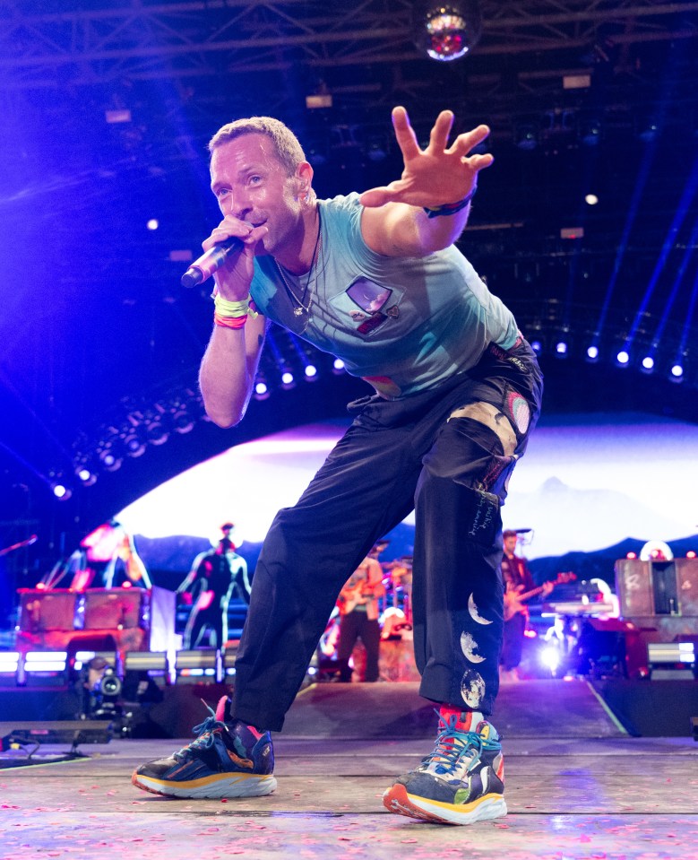 a man in a blue shirt is singing into a microphone