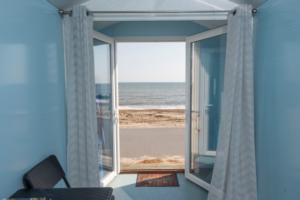 a view of the ocean from a room with a door open