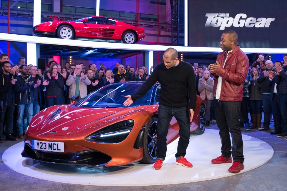 two men standing in front of a car with a license plate that says y23 mcl