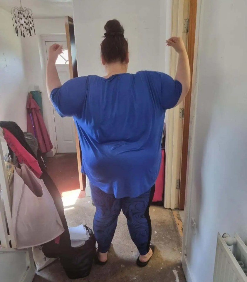 a woman in a blue shirt is flexing her muscles