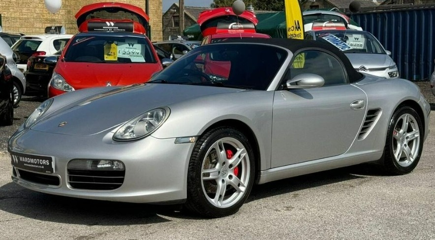 a silver porsche is parked next to a red car