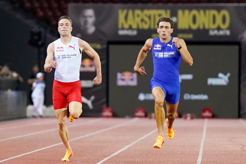 two men are running on a track in front of a sign that says karsten mondo