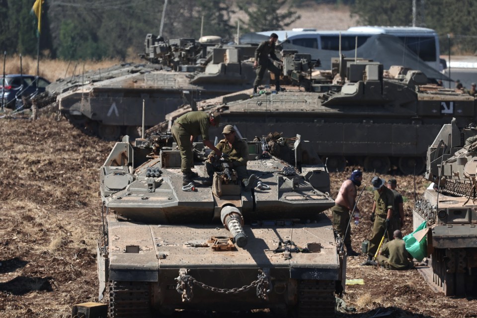 a group of soldiers are working on a tank with the letter a on the side