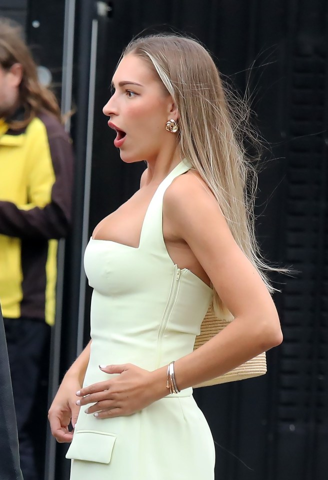a woman in a white dress with her mouth open