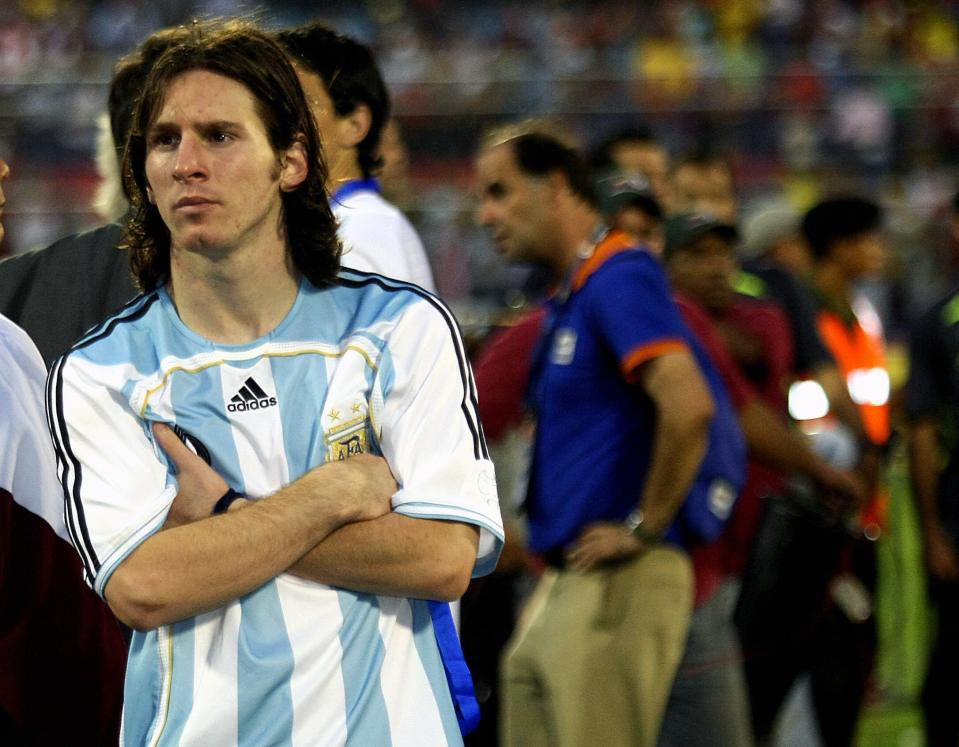 a man wearing an adidas shirt stands with his arms crossed