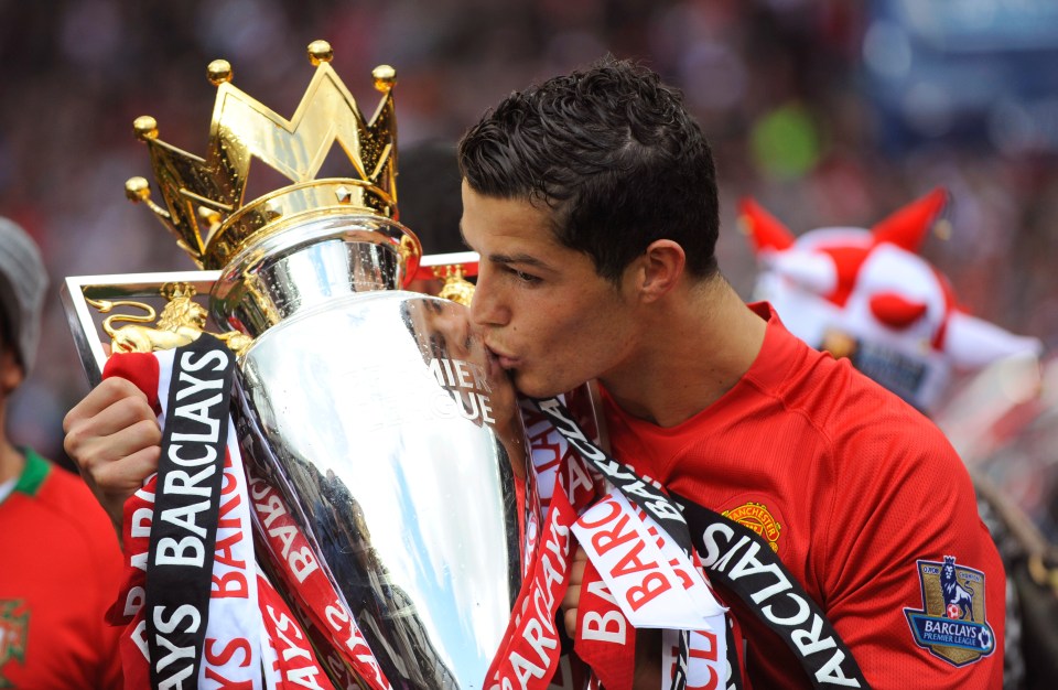 a man kissing a trophy that says barclays on it
