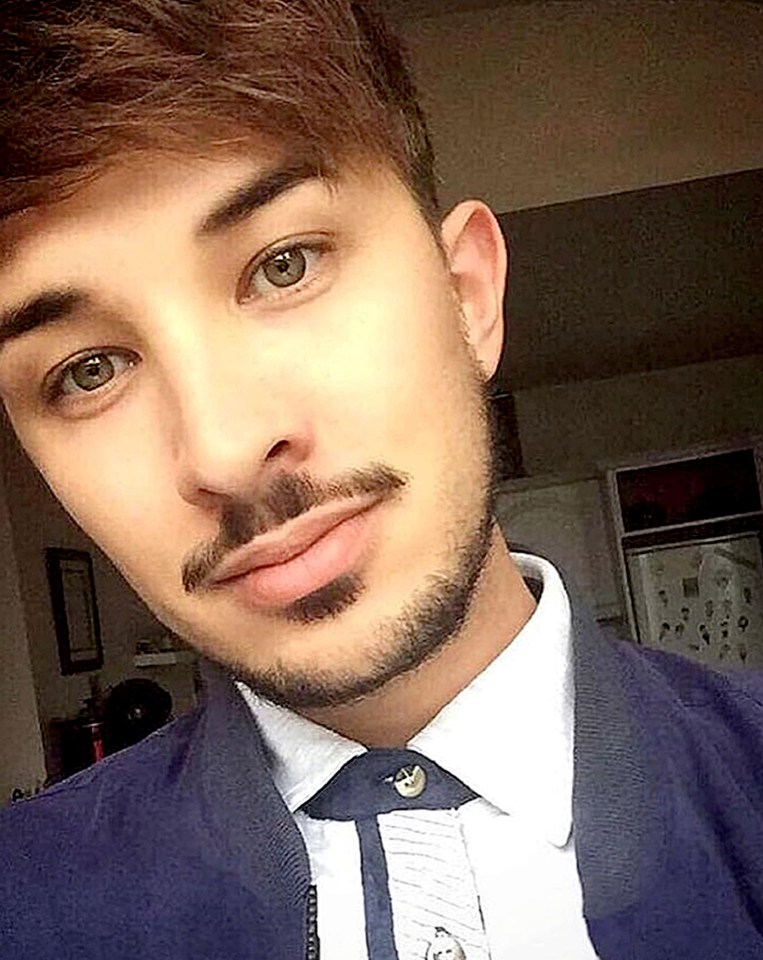 a man with a beard is wearing a blue jacket and a white shirt .