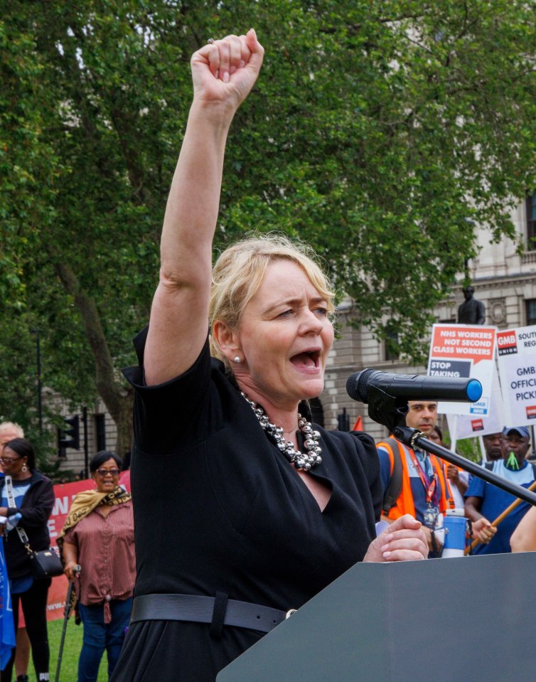 a woman stands at a podium with her fist in the air in front of a sign that says " class women "