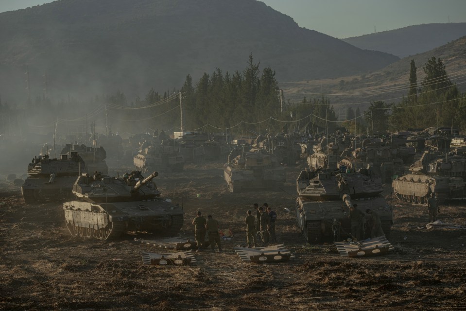 a group of soldiers standing in front of a bunch of military vehicles