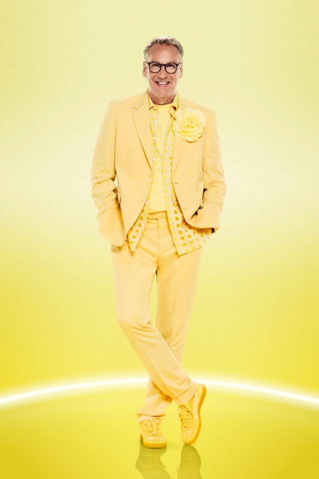 a man in a yellow suit has a flower in his pocket