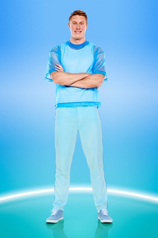 a man in a blue shirt and white pants stands with his arms crossed