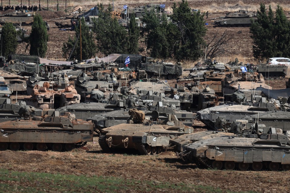 a bunch of military vehicles are parked in a field
