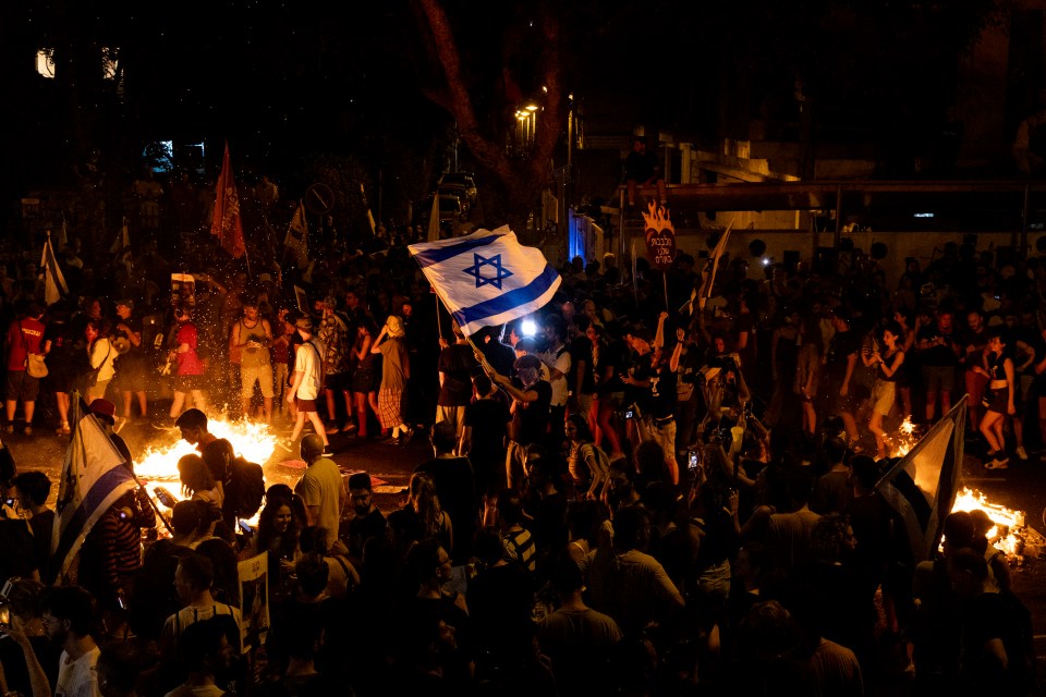 a crowd of people holding flags and a flag with a star on it