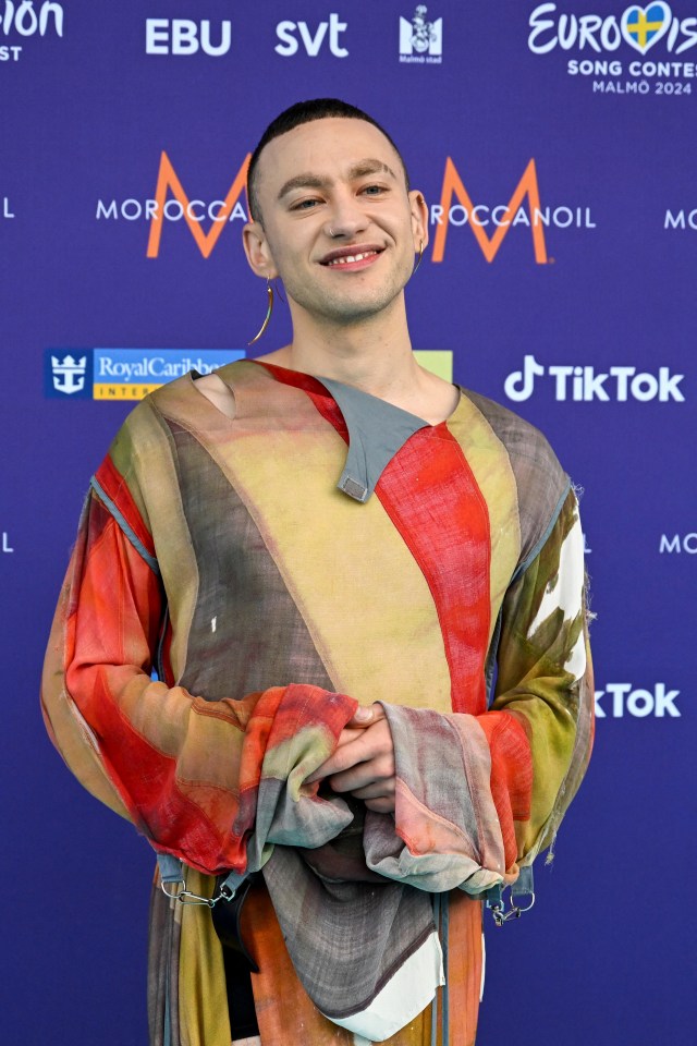 a man stands in front of a purple background that says tiktok