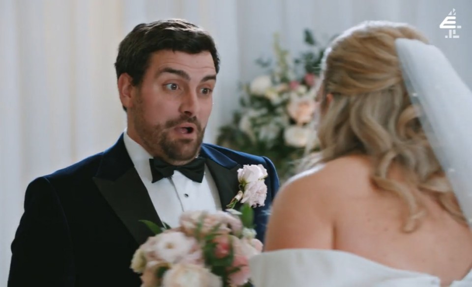a man in a tuxedo stands next to a woman in a wedding dress