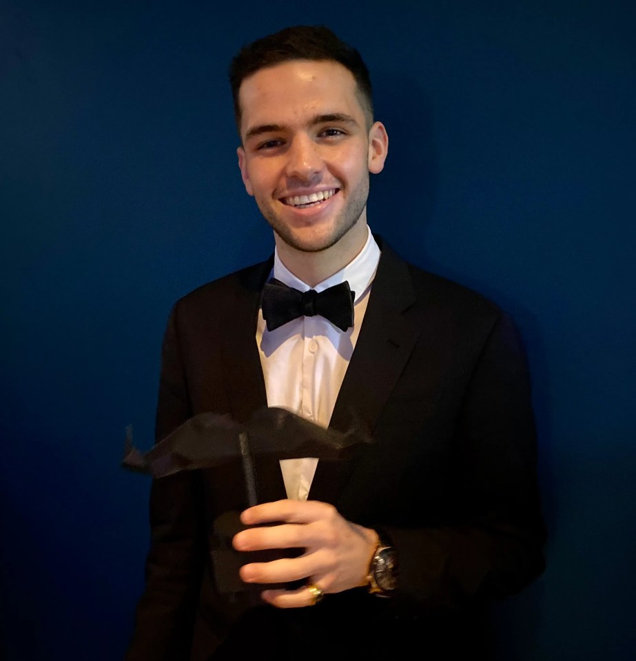 a man in a tuxedo and bow tie holds a black object