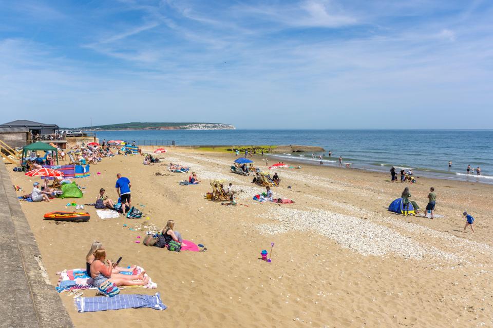 a beach filled with people on a sunny day