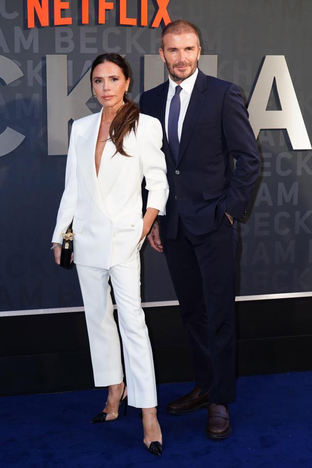 a woman in a white suit stands next to a man in a suit