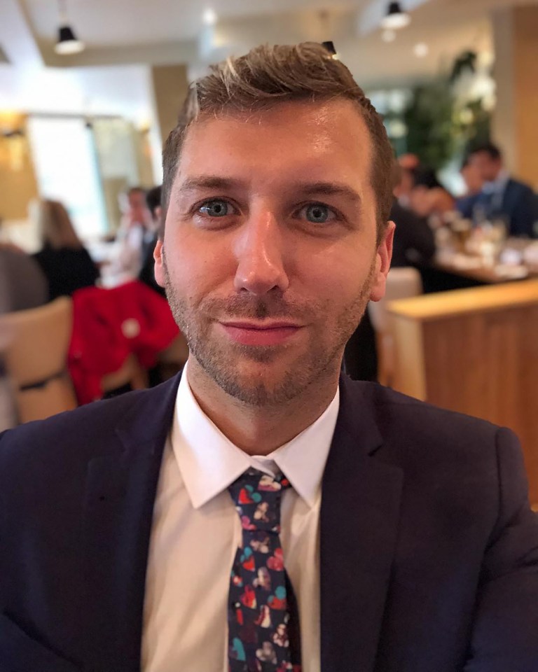 a man in a suit and tie looks at the camera