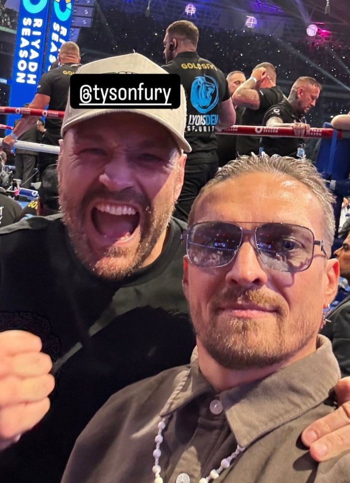two men are posing for a picture and one has the name tysonfury on his shirt