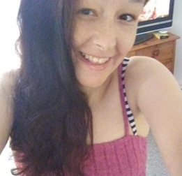 a woman in a pink tank top smiles for the camera