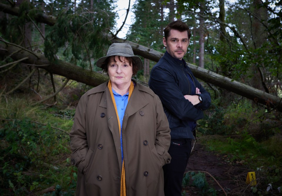 a man and a woman standing next to each other in a forest