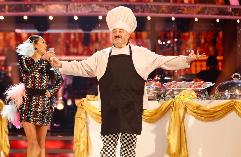 a man in a chef 's hat is dancing with a woman