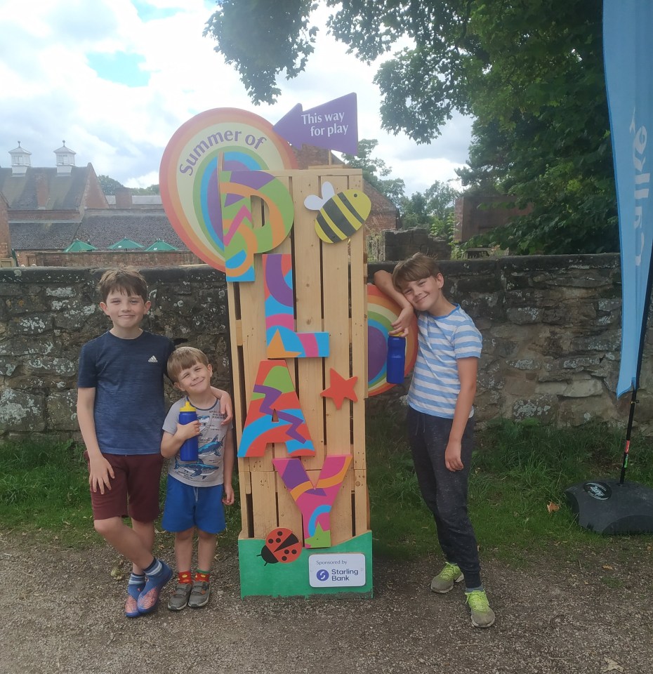 three children stand in front of a sign that says summer of 6