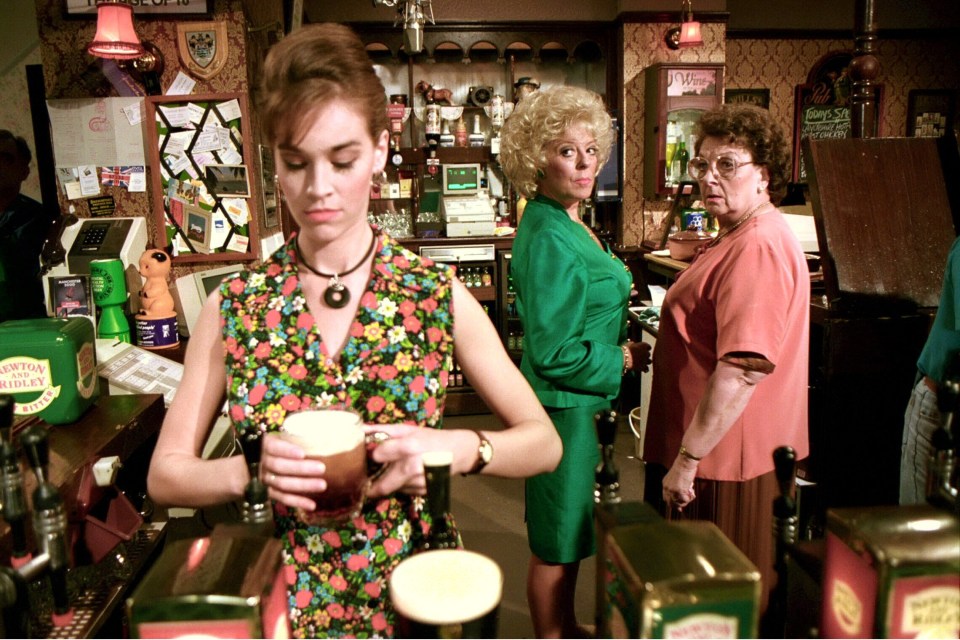 a woman pouring a glass of beer in front of a mountain dew box