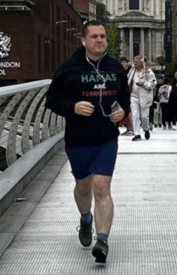 a man running on a bridge in front of a building that says city of london school
