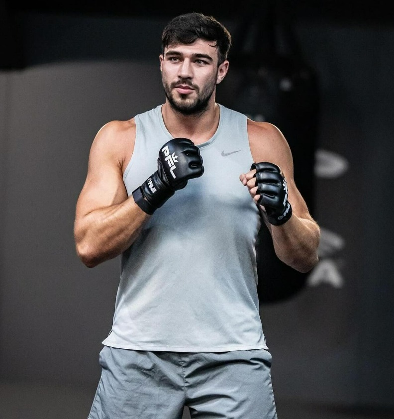 a man wearing boxing gloves and a nike tank top