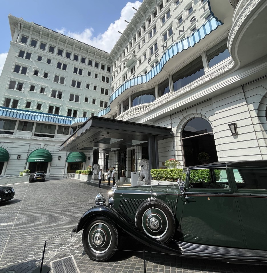 a green car is parked in front of a hotel