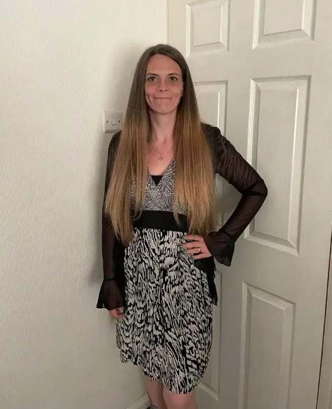 a woman in a black and white dress stands in front of a door