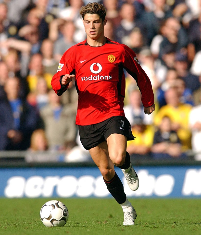 a man in a red vodafone jersey runs with a soccer ball